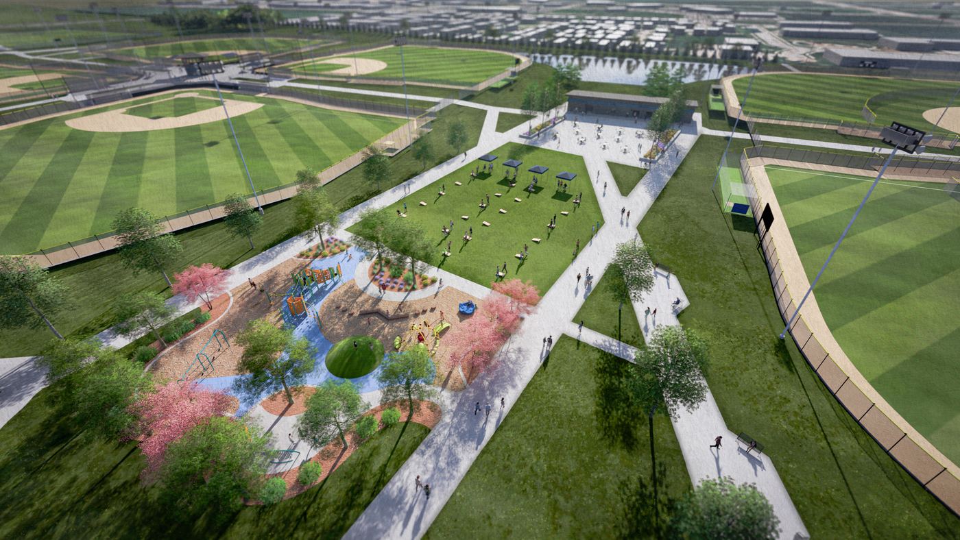 Aerial view of the central lawn set up with games and shade canopies, the playground alongside it and the pavilion beyond.